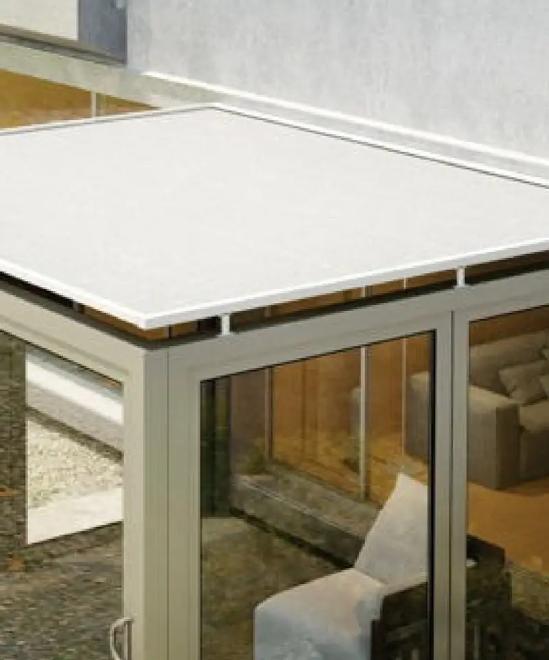 Toldo com guias laterais sobre uma varanda de esquadrias de vidro e estrutura clara.
